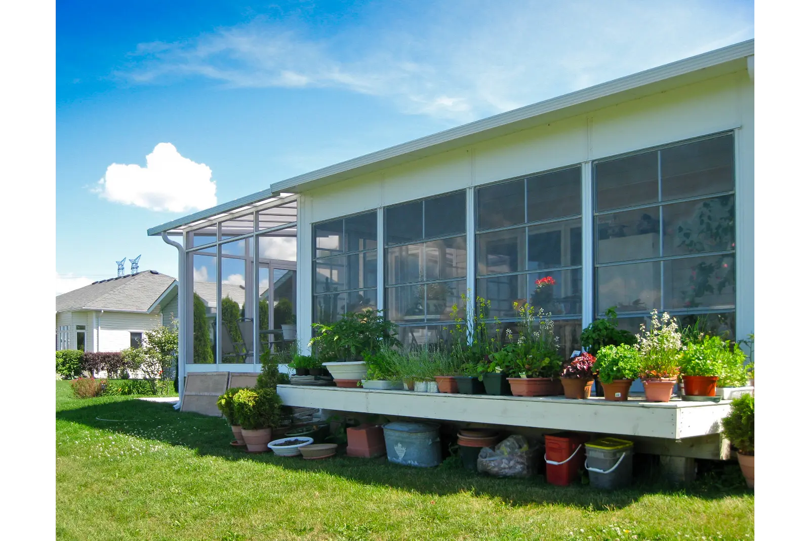 Sunspace Sunrooms Model 100 with large windows and a garden-filled patio.