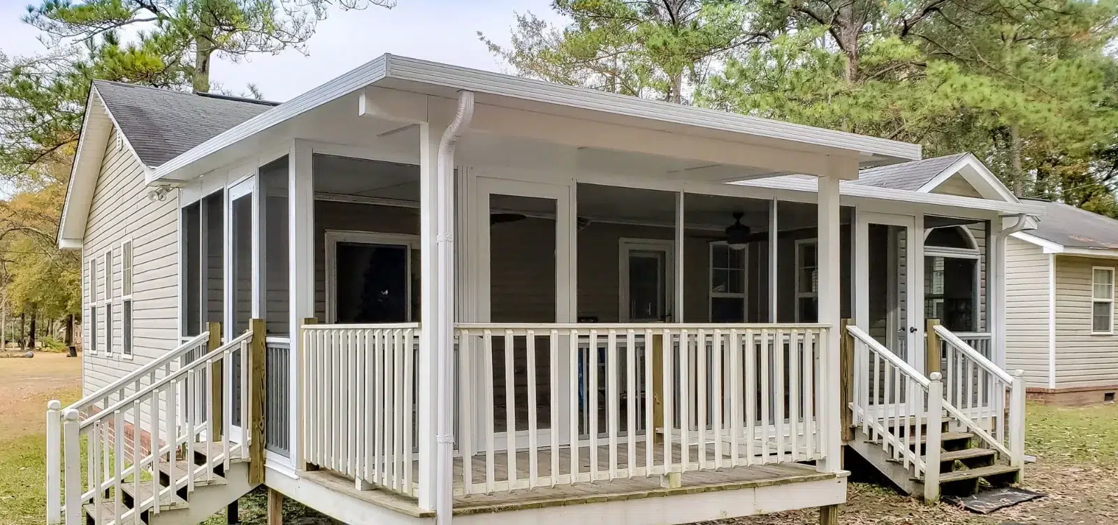 Sunspace Sunrooms Model 100 featuring a white aluminum frame, screened enclosure, and an elevated deck with railings.